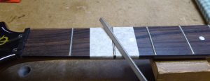 Filing down the top of a hight fret on a Gibson Firebird