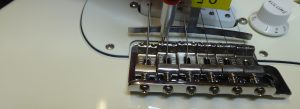 Adjusting the saddle heights on a fender stratocaster to match the radius of the fretboard