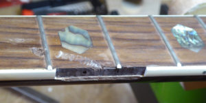 close up of broken neck binding on an acoustic guitar