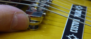 Closeup view of a new bridge, with roller saddles, on a Gibson ES335