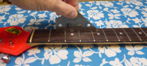 Using a fret rocker to assess how uneven the frets are on a Stratocaster guitar