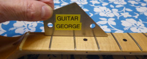 Assessing how even the frets are on a guitar neck with a fret rocker